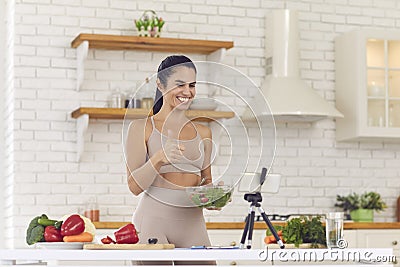 Smiling fit vlogger filming culinary video blog, giving dieting advice and sharing salad recipe Stock Photo