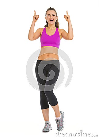 Smiling fitness young woman pointing up on copy space Stock Photo