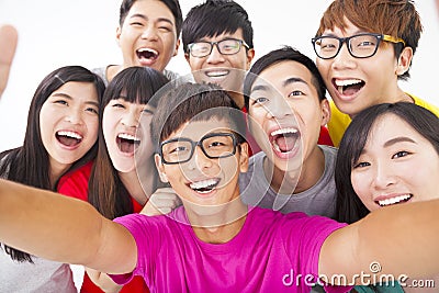 smiling friends with camera taking self photo Stock Photo