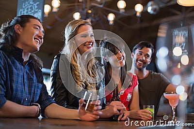 Smiling friends counter looking away in pub Stock Photo