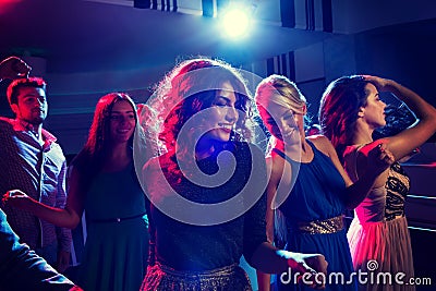 Smiling friends dancing in club Stock Photo