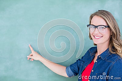 Smiling geeky teacher pointing the blackboard Stock Photo