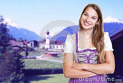 Smiling german woman in bavarian dirndl with rural landscape Stock Photo