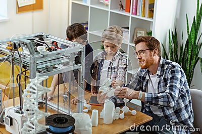 Smiling ginger tutor having practice lesson with interested students Stock Photo