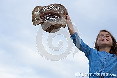 Horizontal photo of a smiling girl who holds her hat Stock Photo