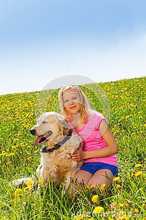 Smiling girl cuddling dog sitting on the grass Stock Photo