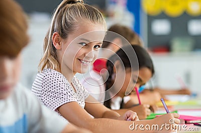 Smiling girl doing classwork Stock Photo