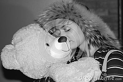 Smiling girl embracing bear shaped pelouche Stock Photo