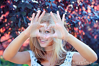 Smiling girl with heart sign Stock Photo