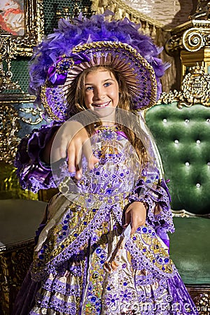 Smiling girl in old-fashione dress and hat holds Stock Photo