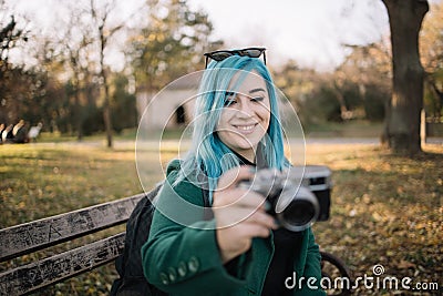 Smiling girl shooting nature with retro camera Stock Photo