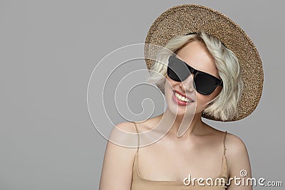 Smiling girl with a short haircut in a hat and sunglasses. Stock Photo