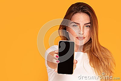 Smiling girl showing mobile phone with empty screen Stock Photo