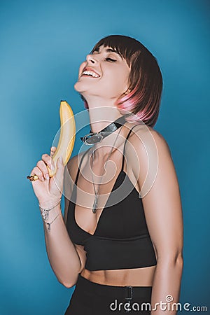smiling girl in stylish crop top holding banana Stock Photo