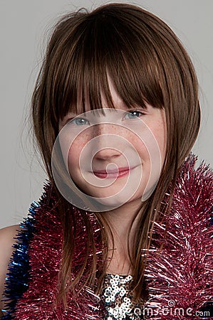 Smiling girl with tinsel, studio shot Stock Photo