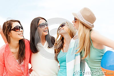 Smiling girls with ball and towel on the beach Stock Photo