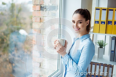 Smiling glad happy manager having a break and drinking tea at work Stock Photo