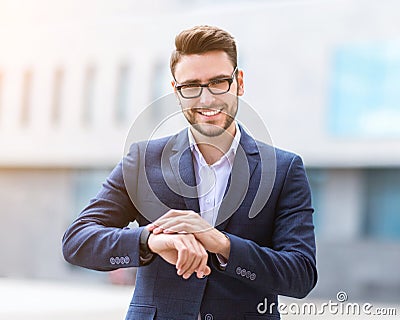 Smiling government official in business suit checking time on his watch at downtown area Stock Photo