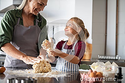 Smiling grandmother and happy child kneading dough Stock Photo