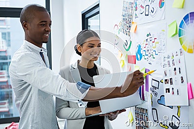 Smiling graphic designers discussing over charts and graph Stock Photo