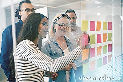 Smiling coworkers brainstorming with sticky notes in an office Stock Photo