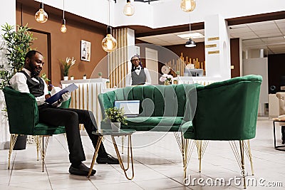 Smiling guy bellboy at hotel lobby Stock Photo