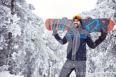 Smiling male snowboarder on the mountain Stock Photo
