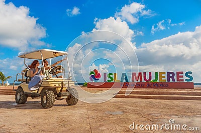 Couple driving a golf cart at tropical beach on Isla Mujeres, Mexico Stock Photo