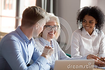 Smiling mature female mentor executive talking at diverse group meeting Stock Photo