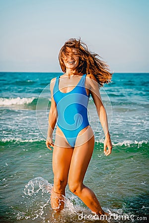 Smiling, happy woman in bikini playful on paradise tropical beach with ocean. Stock Photo