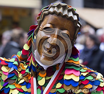 Smiling happy wooden mask in a street parade Editorial Stock Photo