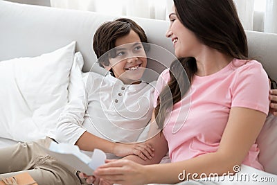 Cute boy hugging his mother in bed Stock Photo