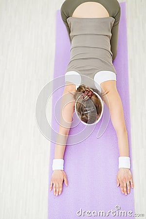 Smiling healthy woman on fitness mat doing yoga Stock Photo
