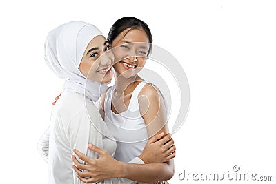 Smiling hijab girl and asian young girl bestfriend in front of camera with copy space Stock Photo