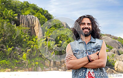 Smiling hippie man in denim vest on island beach Stock Photo