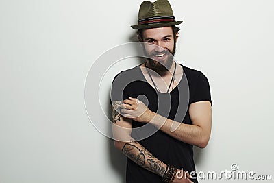 Smiling Hipster boy. handsome man in hat. Brutal bearded boy with tattoo Stock Photo