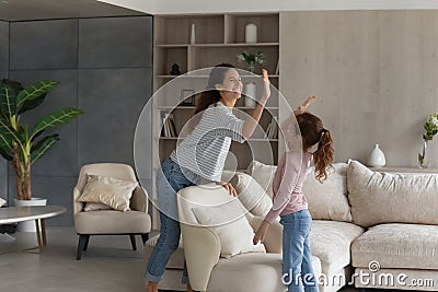 Smiling Hispanic mom and daughter give high five five Stock Photo