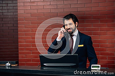 smiling hotel receptionist taking phone call Stock Photo