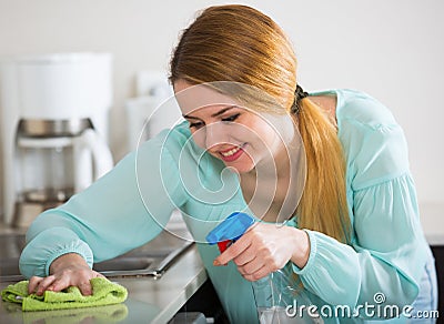 Smiling housewife cleaning up in domestic kitchen Stock Photo