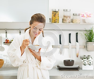 Smiling housewife having healthy breakfast in kitchen Stock Photo