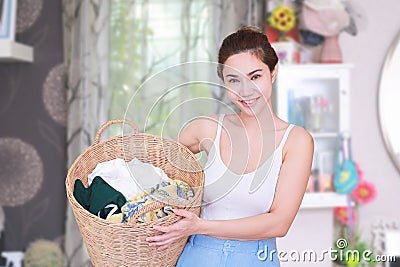 Smiling housewife posing with basket with clean laundry. Stock Photo