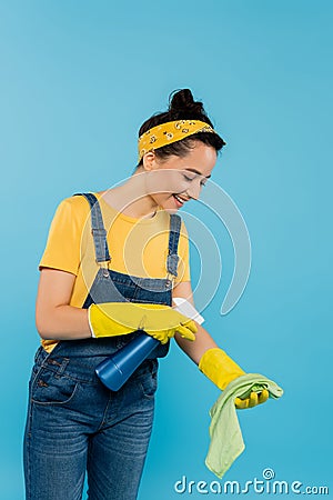 smiling housewife spraying detergent on rag Stock Photo