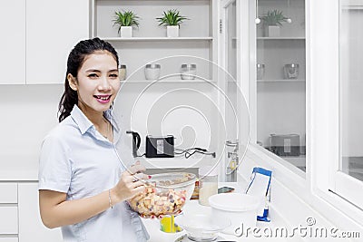 Smiling housewife stirring apple in bowl Stock Photo