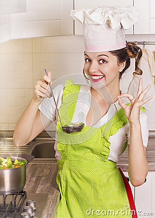 Smiling housewife tasting soup with ladle Stock Photo