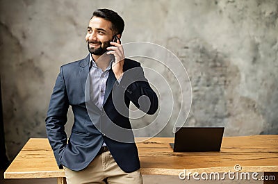 Smiling Indian high skilled leader talking on the smartphone Stock Photo