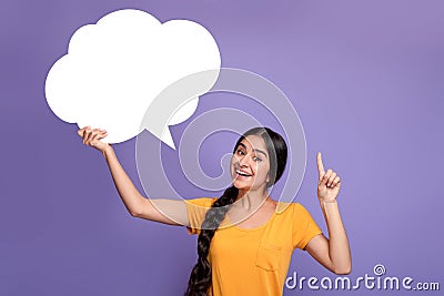 Smiling indian woman pointing finger up hoding speech bubble Stock Photo