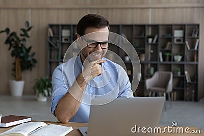 Smiling intelligent young man sit by laptop at scientific laboratory Stock Photo