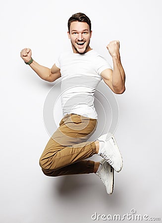 Smiling joyful man jumping on a white background. Stock Photo