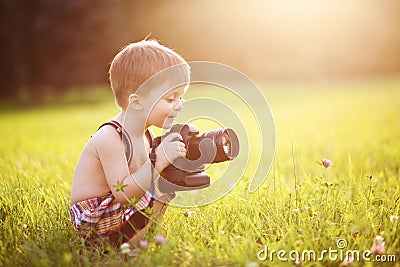 Smiling kid holding a DSLR camera in park Stock Photo