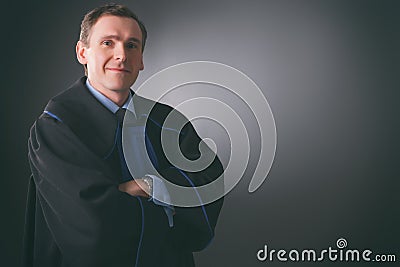 Smiling lawyer in a toga stands with his arms folded Stock Photo